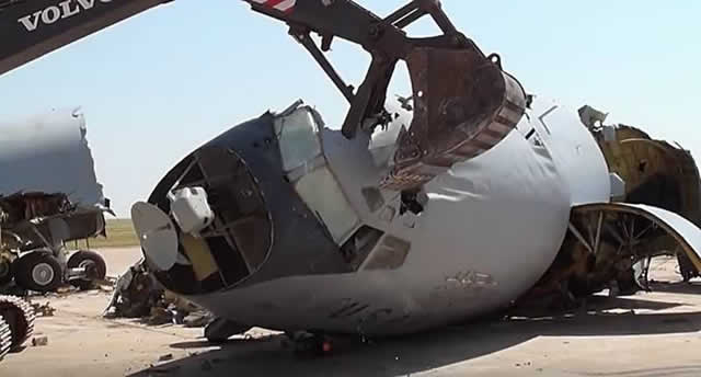 Excavator crushing the front fuselage of an aircraft